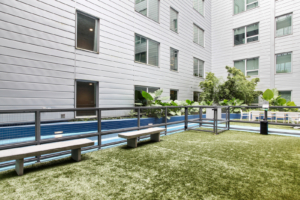 On-site, fenced in dog park with benches located at The Beacon at South Market apartment community in New Orleans.